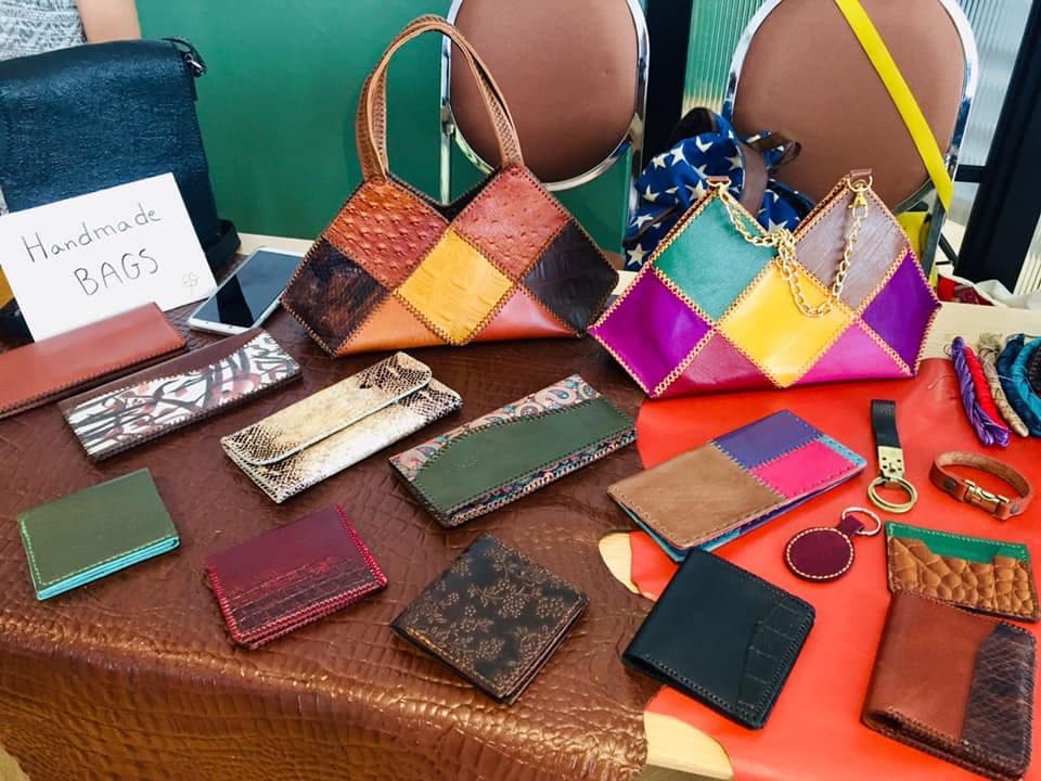 Handmade bags and small goods arranged on a table for sale.
